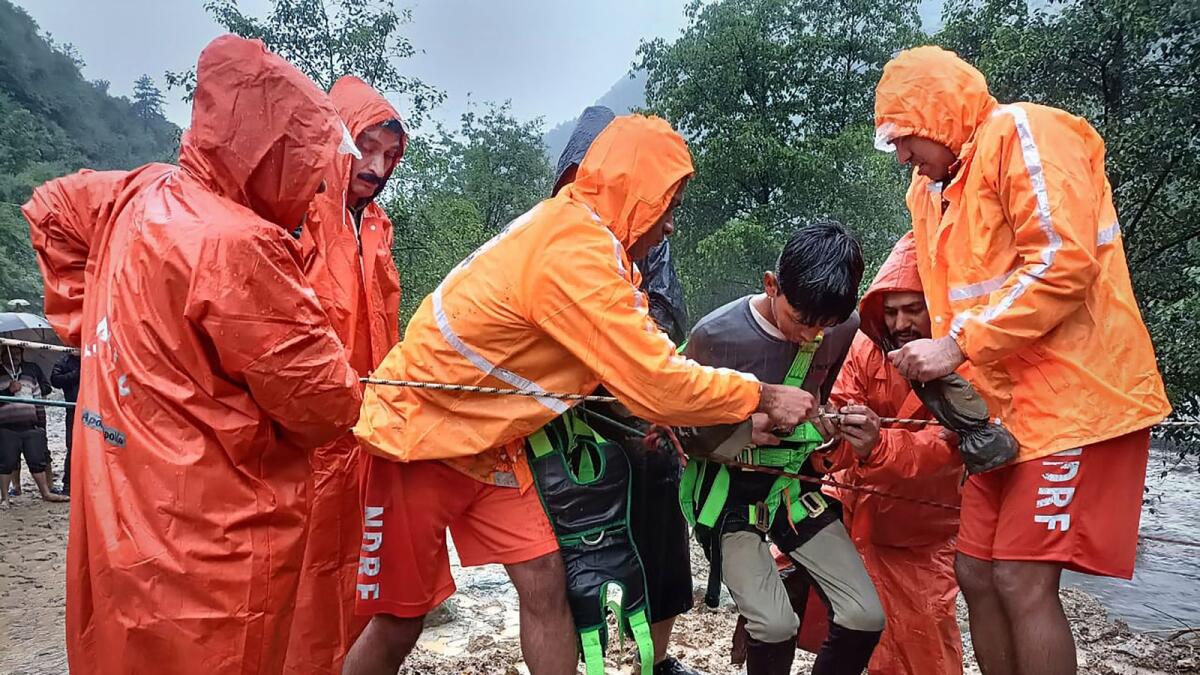 أفراد القوة الوطنية للاستجابة للكوارث (NDRF) ينقذون طفلاً وسط فيضانات مفاجئة بسبب الأمطار الموسمية الغزيرة في منطقة كولو.  - PTI