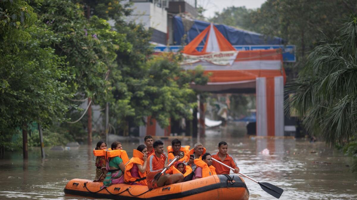 يقوم أفراد القوة الوطنية للاستجابة للكوارث (NDRF) بإجلاء السكان الذين تقطعت بهم السبل من منطقة غمرتها الفيضانات ، بعد ارتفاع منسوب مياه نهر يامونا.  - رويترز