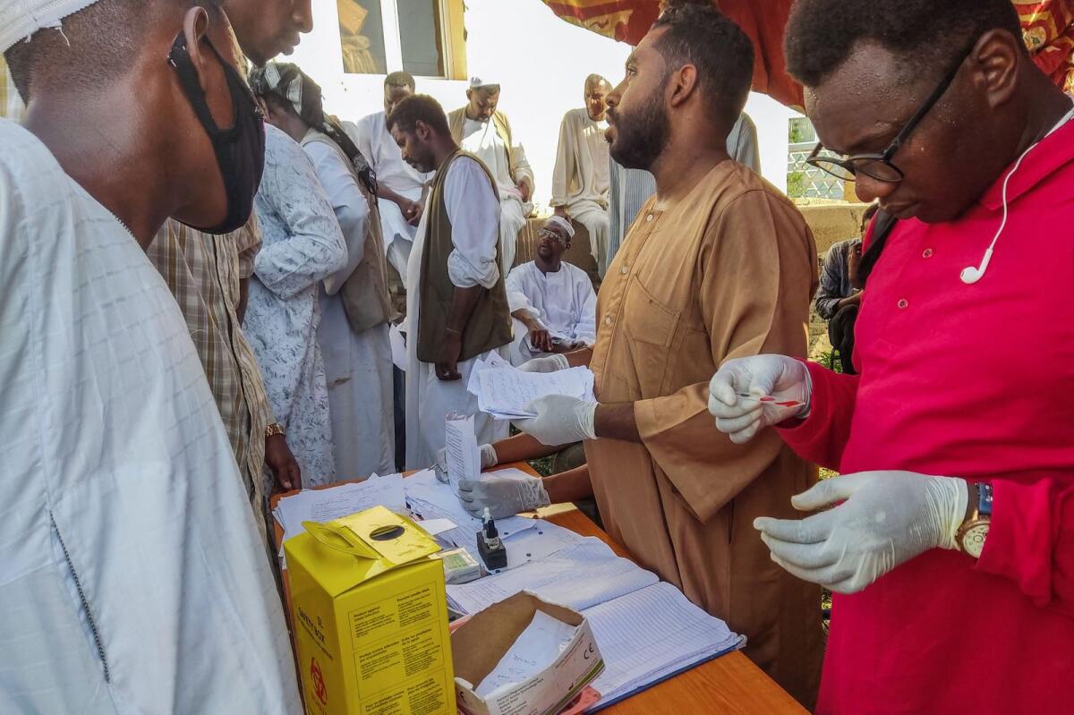 أشخاص يصطفون أمام مختبر طبي لإجراء اختبار حمى الضنك في ولاية القضارف شرق السودان التي مزقتها الحرب في 22 سبتمبر 2023، وسط تقارير عن انتشار العدوى الفيروسية.  – وكالة فرانس برس