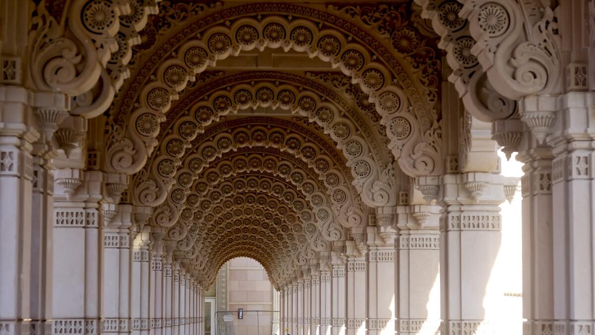 رجل في BAPS Swaminarayan Akshardham يقوم بفحص هاتفه داخل المسار الذي يشبه الإكليل، أو parikrama، والذي يعد بمثابة ممر مزخرف مغطى إلى أكبر معبد هندوسي خارج الهند في العصر الحديث.  — ا ف ب