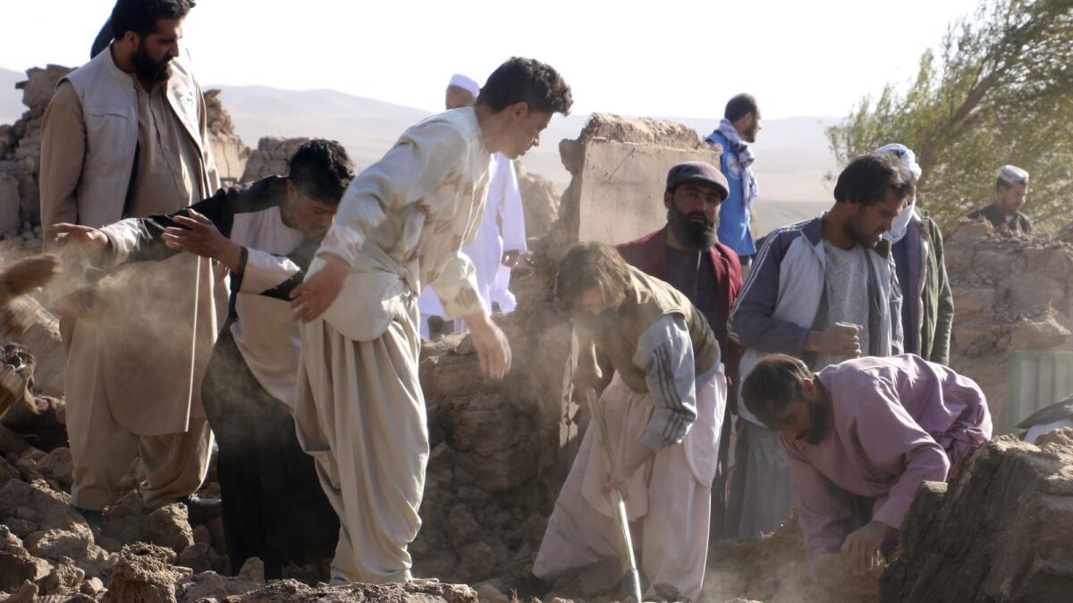 رجال أفغان يبحثون عن الضحايا بعد وقوع زلزال في منطقة زندا جان.