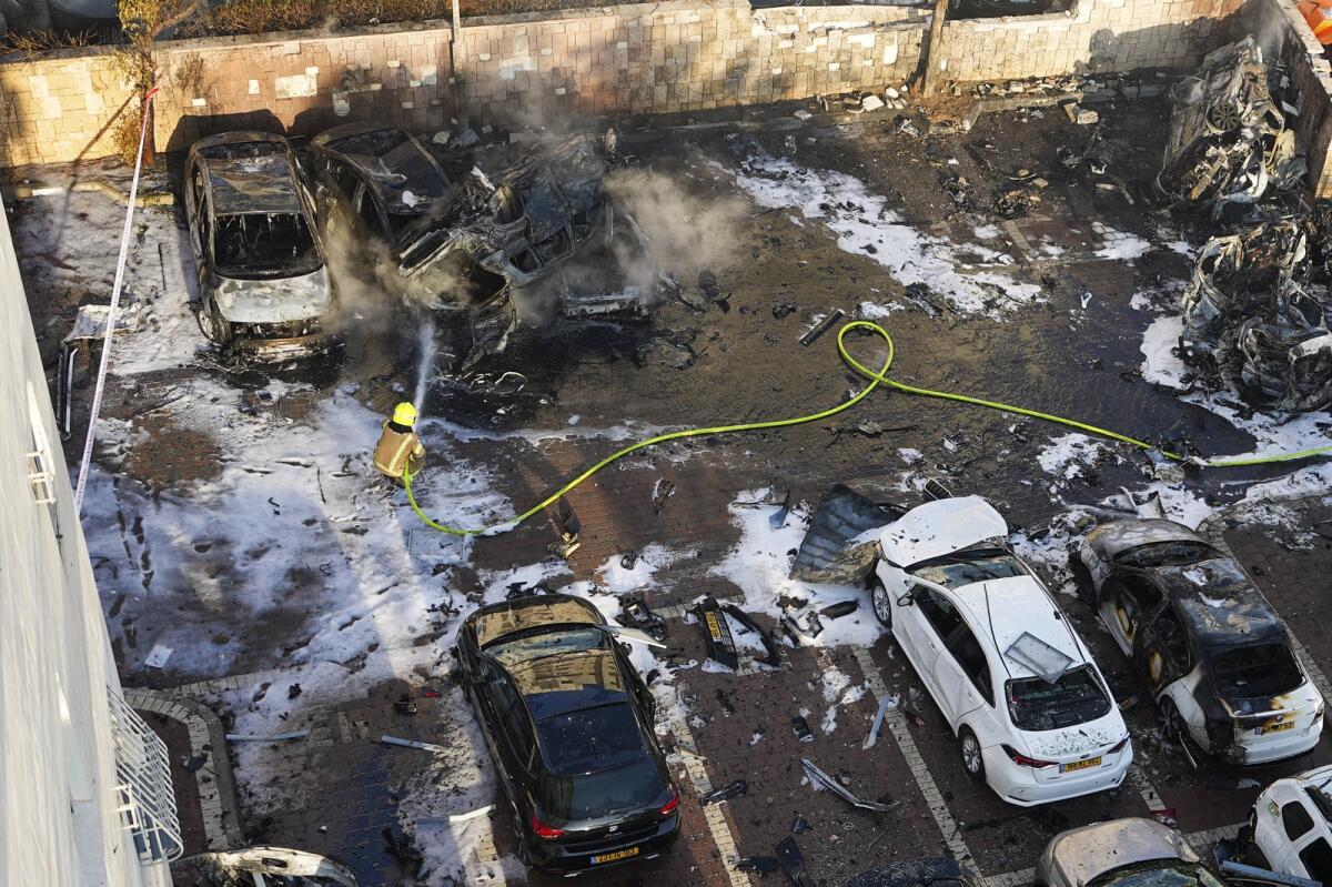 رجال الإطفاء الإسرائيليون يطفئون حريقًا بعد أن أصاب صاروخ أطلق من قطاع غزة ساحة انتظار للسيارات في عسقلان، جنوب إسرائيل، السبت 7 أكتوبر 2023. الصورة: AP