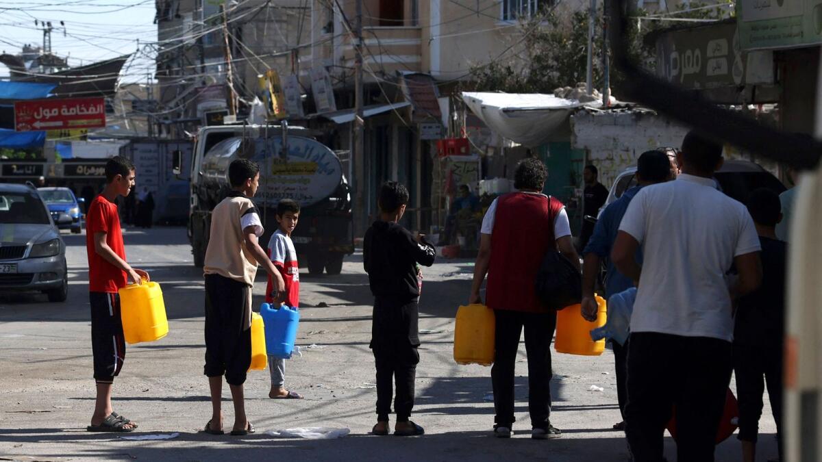 فلسطينيون يصطفون للحصول على المياه في مخيم رفح للاجئين جنوب قطاع غزة.  – وكالة فرانس برس