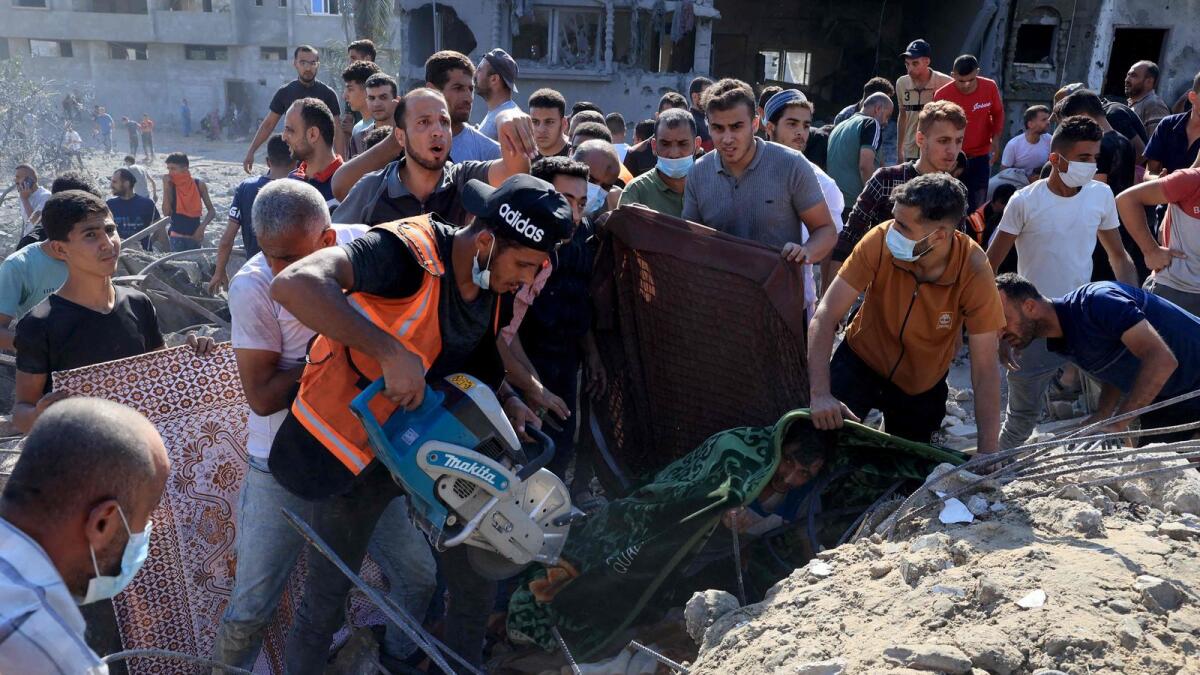 فلسطينيون يعملون على إزالة أنقاض مبنى منهار في أعقاب غارة جوية إسرائيلية في رفح، جنوب قطاع غزة، في 16 أكتوبر 2023. الصورة: وكالة فرانس برس