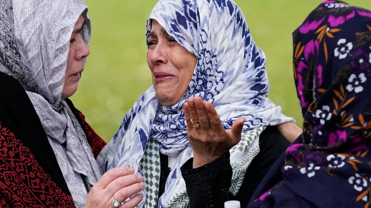 أبناء الجالية الإسلامية يبكون على قبر وديع الفيوم في لاجرانج.  — ا ف ب