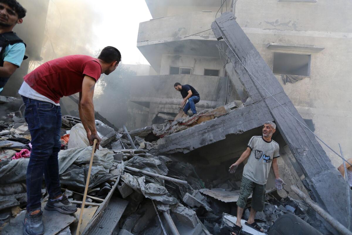 فلسطينيون يبحثون عن ناجين بعد الغارات الجوية الإسرائيلية على مدينة غزة بقطاع غزة يوم الأربعاء.  — ا ف ب