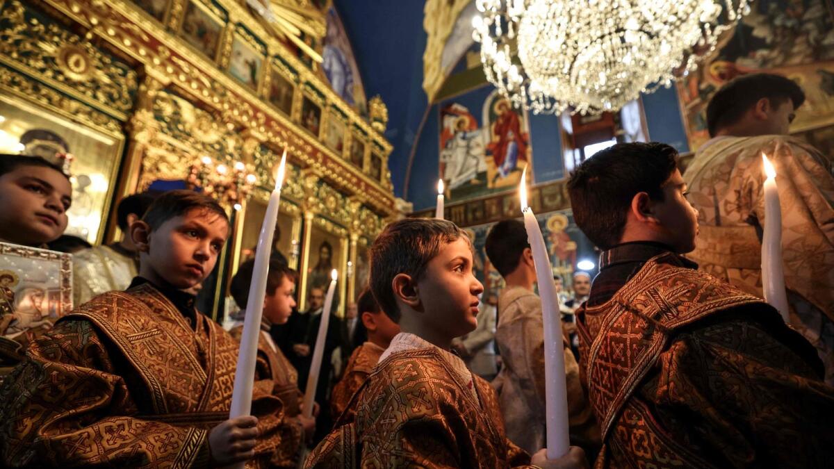 خدام المذبح الشباب يشاركون في قداس عيد الميلاد الأرثوذكسي في كنيسة القديس برفيريوس في مدينة غزة في 7 يناير 2023. AFP