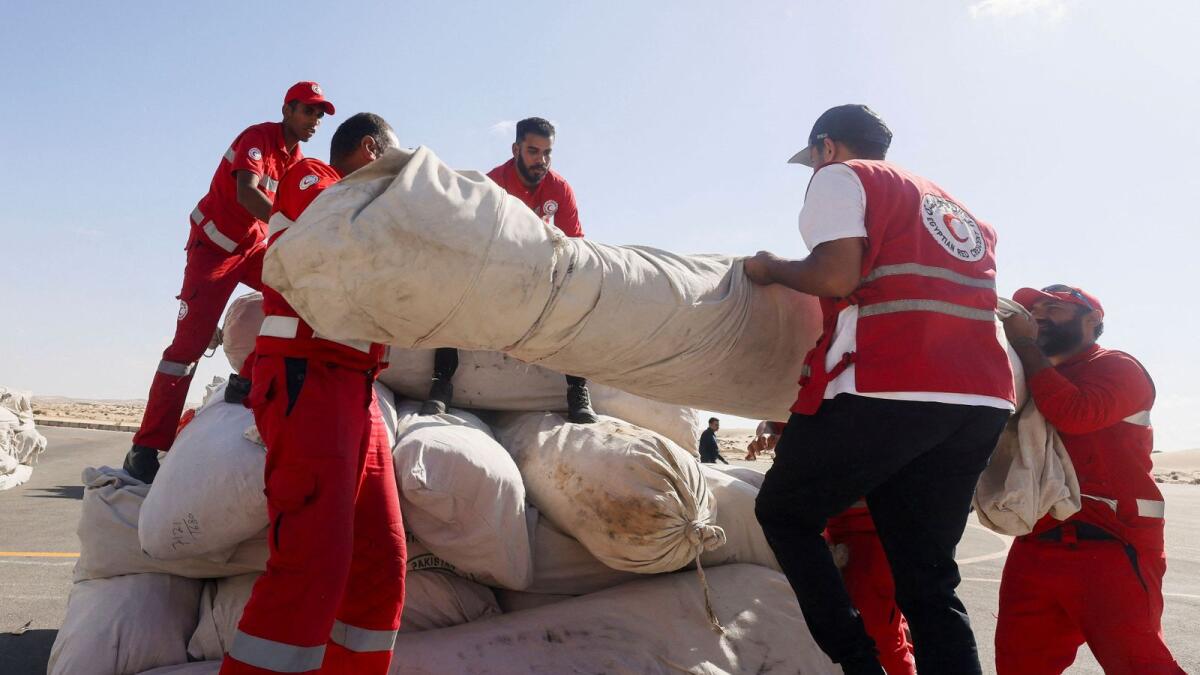 أعضاء الهلال الأحمر المصري ينسقون المساعدات لغزة، بعد زيارة الأمين العام للأمم المتحدة أنطونيو غوتيريش لمعبر رفح الحدودي بين مصر وقطاع غزة، في مطار العريش، مصر، 20 أكتوبر، 2023. رويترز