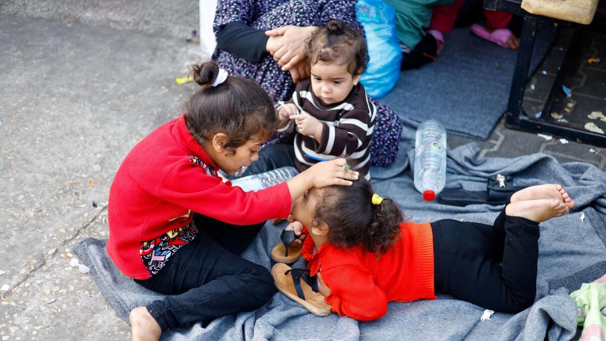 أطفال فلسطينيون، فروا من منازلهم وسط الغارات الإسرائيلية، يحتمون بمدرسة تديرها الأمم المتحدة في خان يونس.  – رويترز