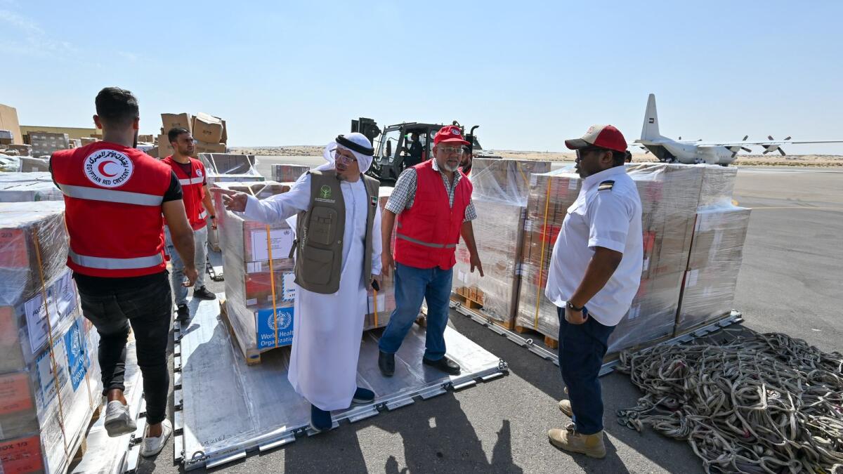 مسؤولون يتفقدون الإمدادات الغذائية والطبية التي تم تفريغها في قاعدة العريش الجوية في مصر.