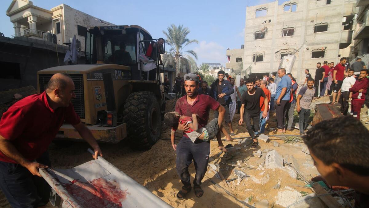 فلسطينيون يسحبون صبيًا من تحت الأنقاض بعد غارة إسرائيلية على منزل عائلة زروب في رفح، قطاع غزة، الثلاثاء، 24 أكتوبر، 2023. (صورة AP / حاتم علي)