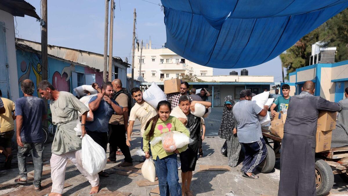 فلسطينيون يقتحمون مركز إمداد المساعدات الذي تديره الأمم المتحدة، والذي يوزع الغذاء على العائلات النازحة في دير البلح.  – وكالة فرانس برس