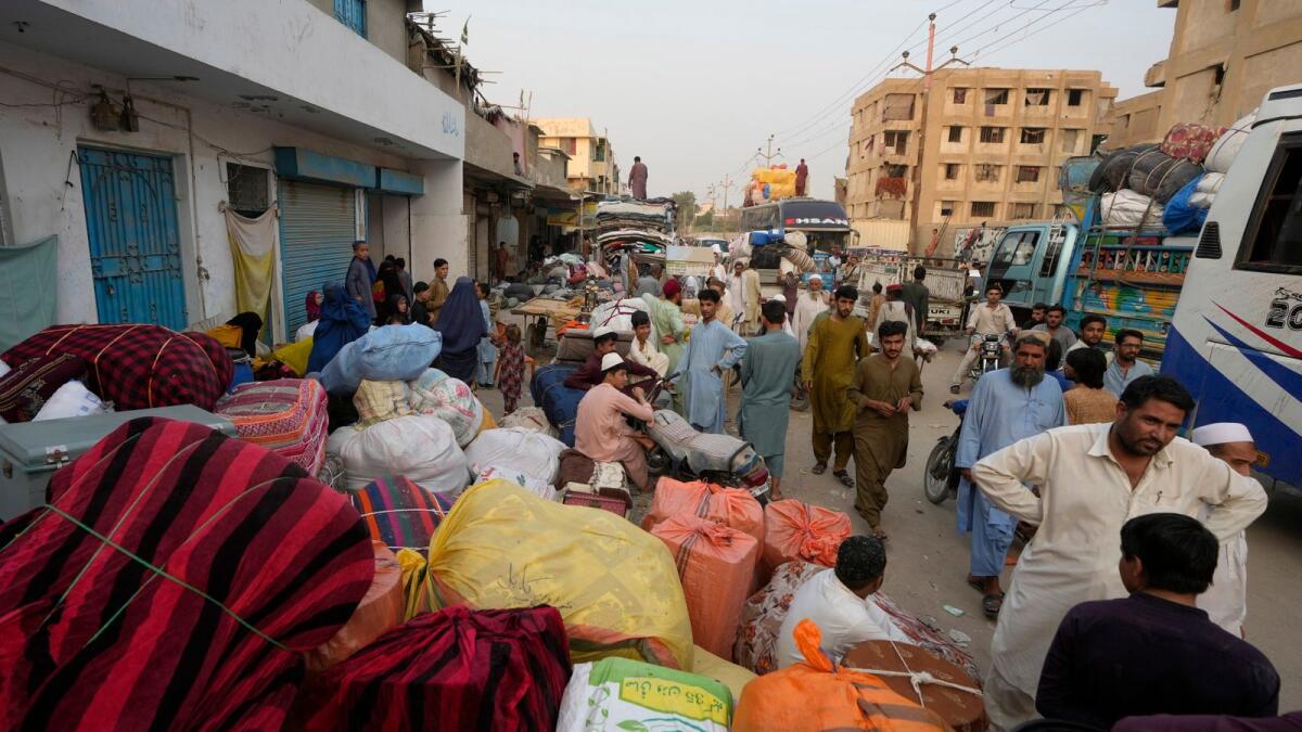 عائلات أفغانية تنتظر ركوب الحافلات للمغادرة إلى موطنها في كراتشي، باكستان، يوم الاثنين.  — ا ف ب