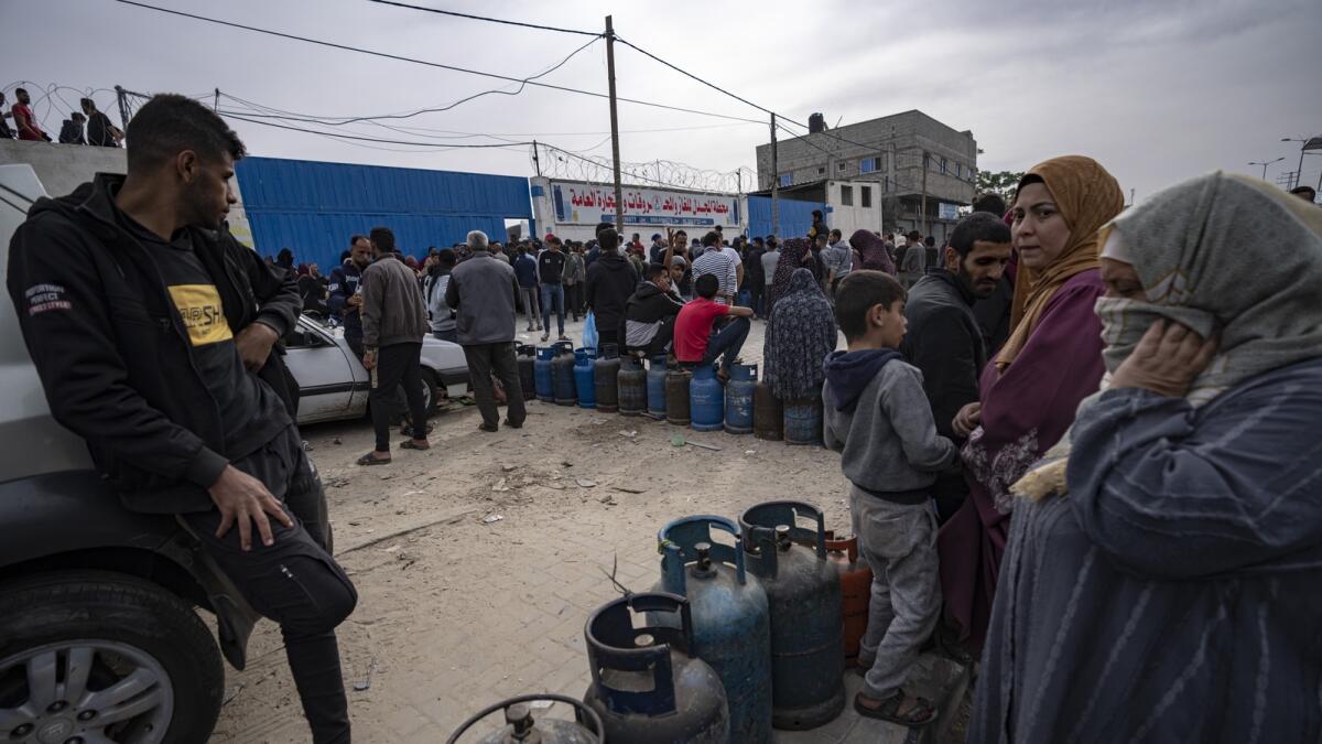 فلسطينيون يصطفون للحصول على غاز الطهي خلال اليوم الثاني من وقف إطلاق النار المؤقت بين حماس وإسرائيل في خان يونس.  — ا ف ب