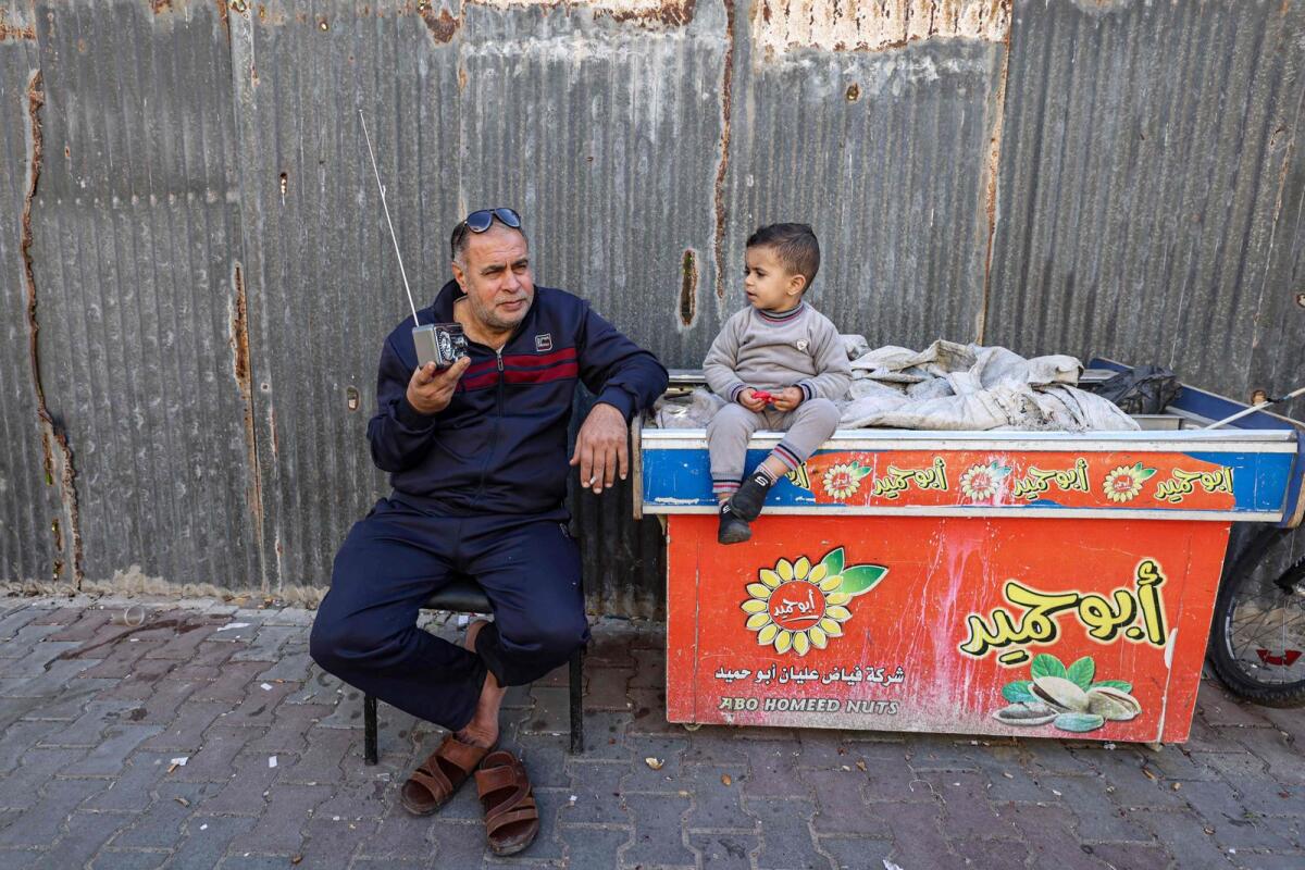 رجل فلسطيني يستمع إلى الراديو الخاص به في مخيم للاجئين في رفح بجنوب قطاع غزة في 19 ديسمبر 2023. — AFP