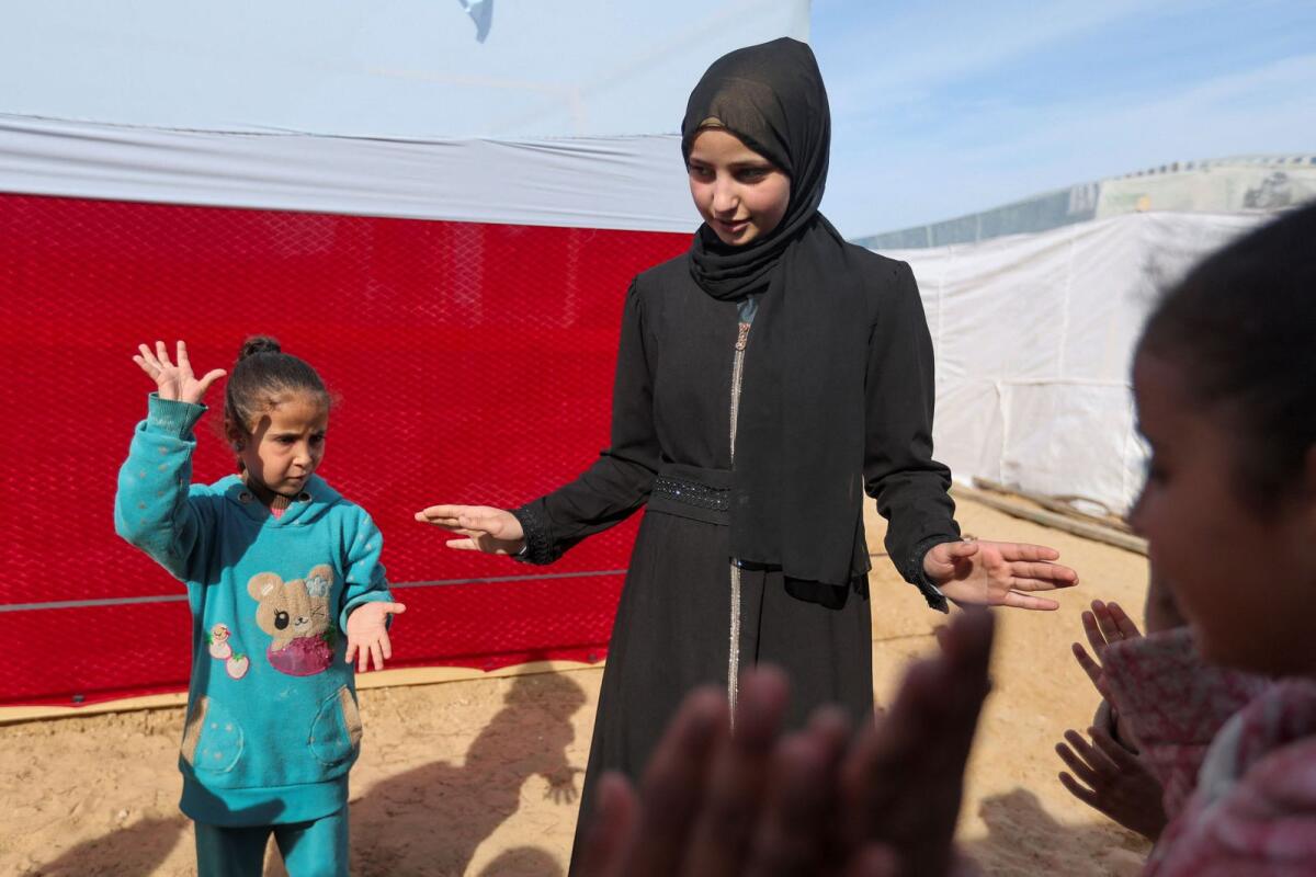 رغد أبو نادي، فتاة فلسطينية نازحة قُتل والدها في غارة إسرائيلية، تلعب مع الأطفال خارج ملجأ عائلتها المؤقت في رفح في 8 يناير/كانون الثاني. - رويترز