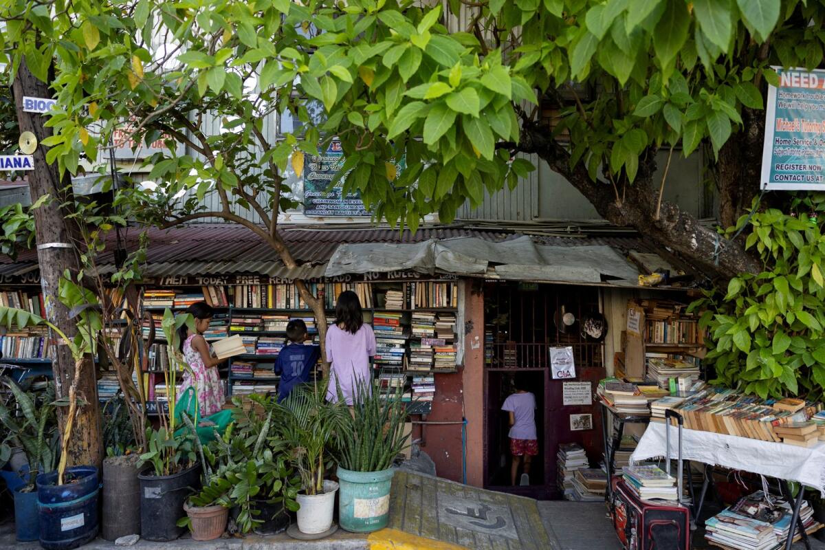 أطفال يتصفحون الكتب في مكتبة هيرناندو جوانلاو المشتركة في ماكاتي، مترو مانيلا، الفلبين، في 7 فبراير 2024. – رويترز