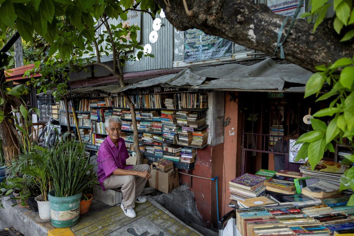 هيرناندو جوانلاو، المعروف أيضًا باسم مانج ناني، 72 عامًا، يقف أمام مكتبته العامة في منزله في ماكاتي، مترو مانيلا، الفلبين، 7 فبراير 2024. – رويترز