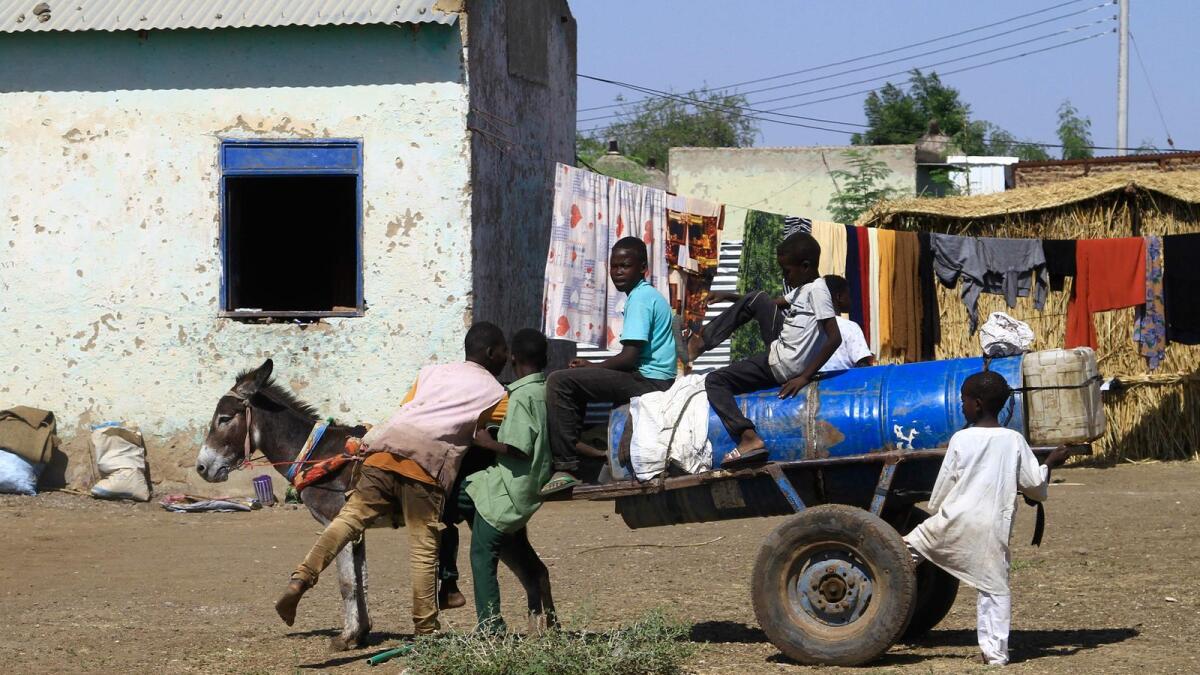 أطفال نازحون من ولاية الجزيرة السودانية ينقلون المياه على عربة يجرها حمار، وهي وسيلة النقل المفضلة للأشخاص والبضائع، مع ارتفاع أسعار الوقود بسبب القتال الداخلي، في مأوى مؤقت في القضارف شرق البلاد في 28 ديسمبر 2023. – وكالة فرانس برس