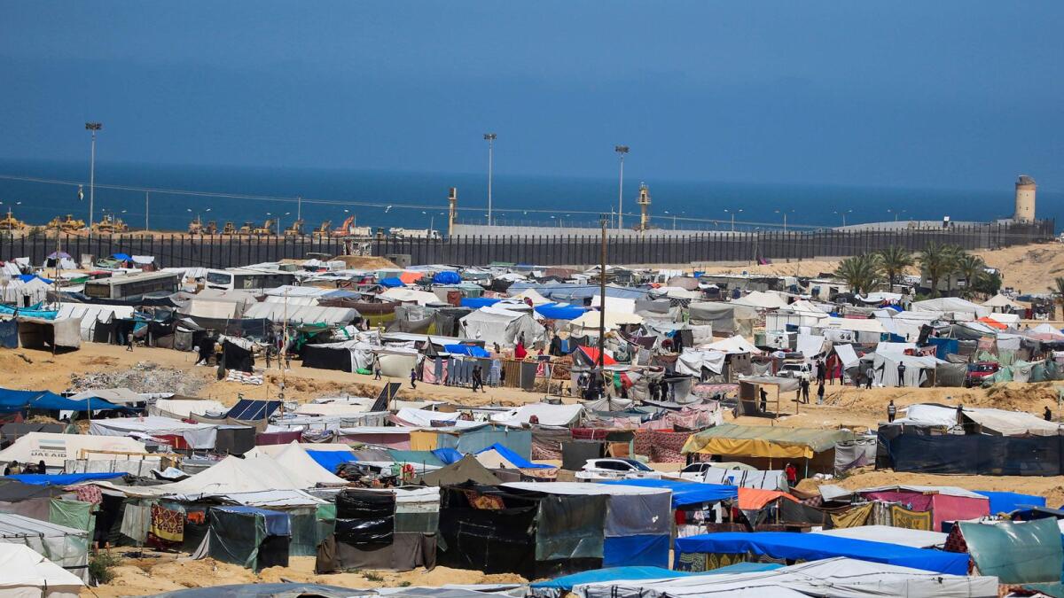 نصب الخيام من قبل النازحين الفلسطينيين في المواصي بالقرب من الحدود مع مصر في رفح.  – الصورة: وكالة فرانس برس