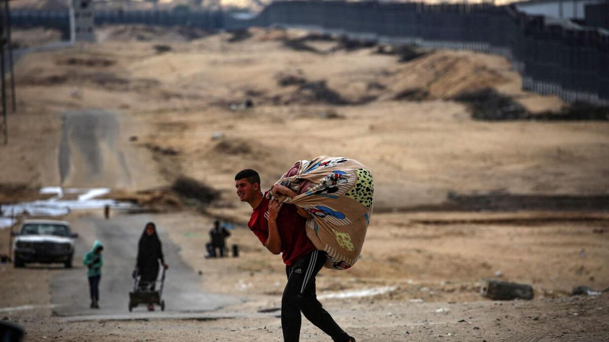 فلسطينيون يحملون أمتعتهم أثناء استعدادهم للفرار من مدينة رفح جنوب قطاع غزة.  – الصورة: وكالة فرانس برس