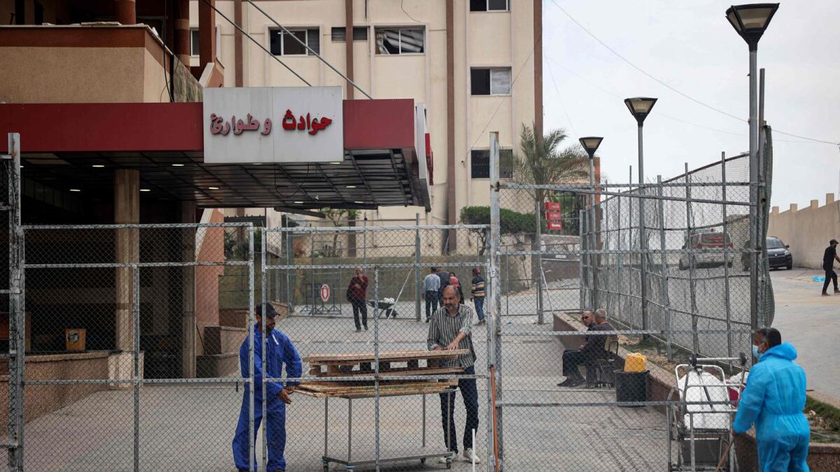 فلسطينيون يعملون على إعادة تأهيل مستشفى ناصر المدمر في خان يونس.  – الصورة: وكالة فرانس برس