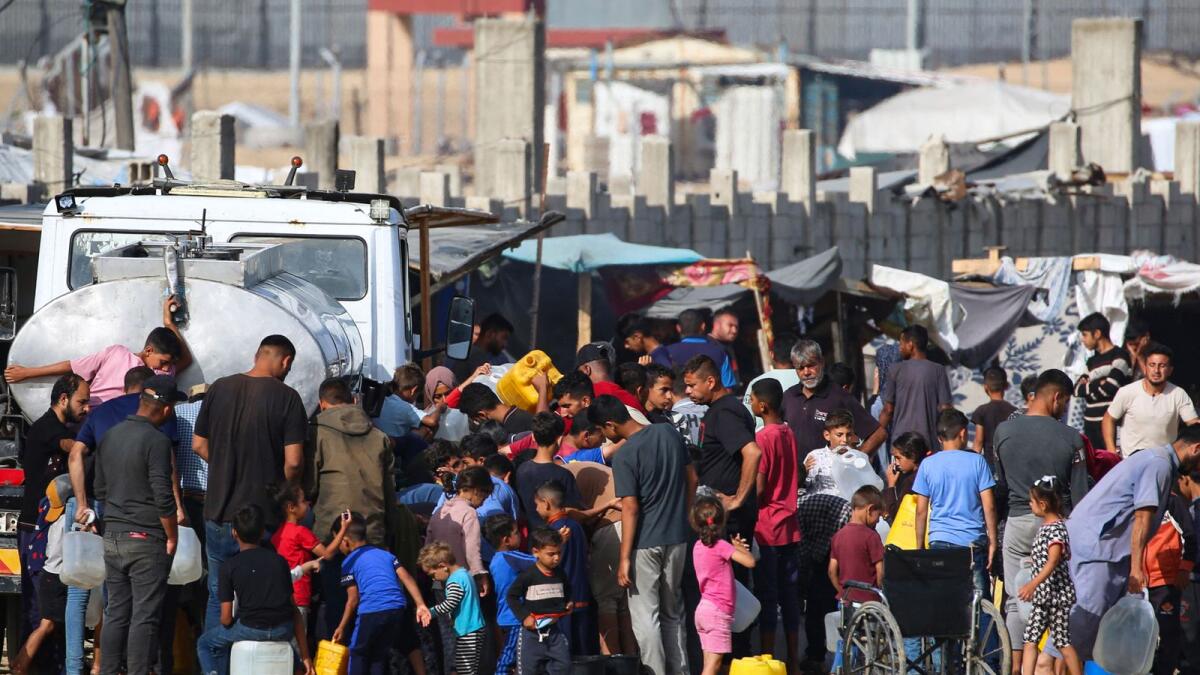 نازحون فلسطينيون يصطفون لشراء المياه من شاحنات المياه بجوار مخيمهم المؤقت في رفح.  – الصورة: وكالة فرانس برس