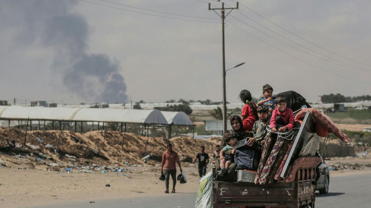 فلسطينيون يفرون بأمتعتهم يركبون فوق سيارتهم في رفح.  – الصورة: وكالة فرانس برس