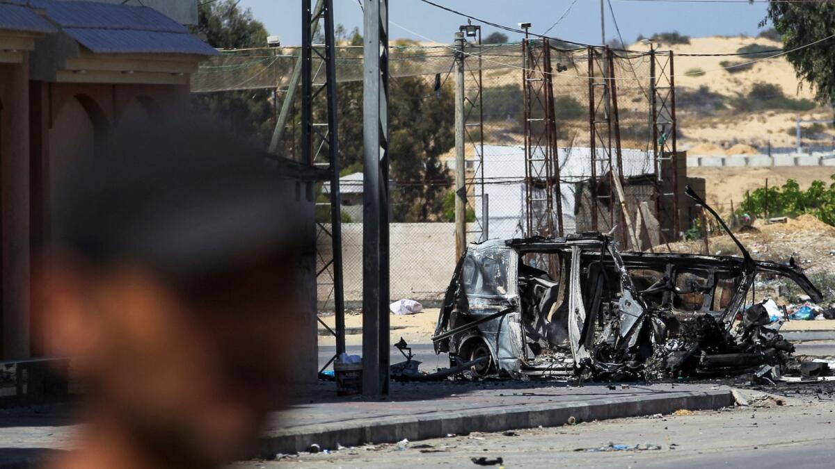 رجل فلسطيني يسير بالقرب من حطام مركبة أصيبت في غارة إسرائيلية في رفح.  – الصورة: رويترز