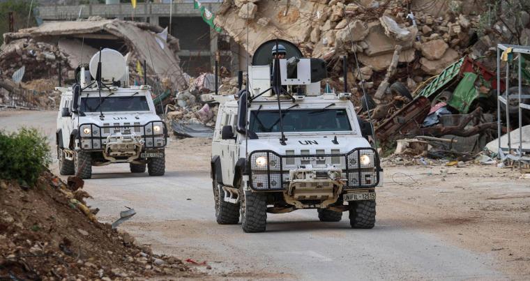 جنود حفظ السلام التابعون للأمم المتحدة يقودون مركبات تابعة لقوة الأمم المتحدة المؤقتة في لبنان (اليونيفيل) بجوار المباني المدمرة أثناء قيامهم بدوريات في قرية كفركلا بجنوب لبنان بالقرب من الحدود مع إسرائيل.